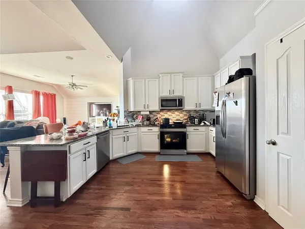a kitchen with stainless steel appliances a refrigerator sink and cabinets