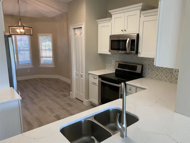 a kitchen with granite countertop a stove and a sink