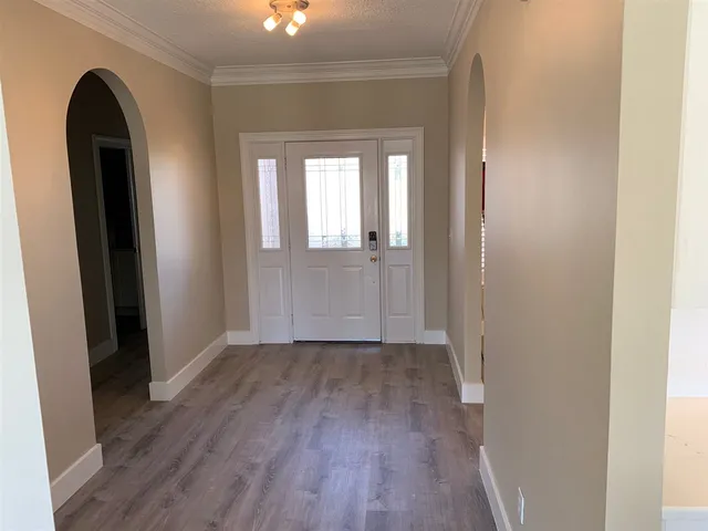 an empty room with wooden floor and a window