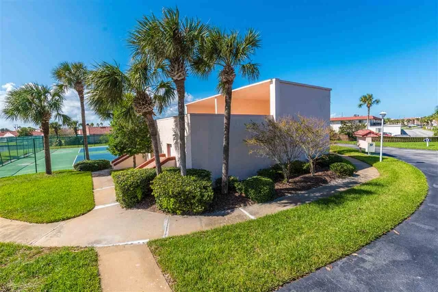 a view of a house with a yard and potted plants