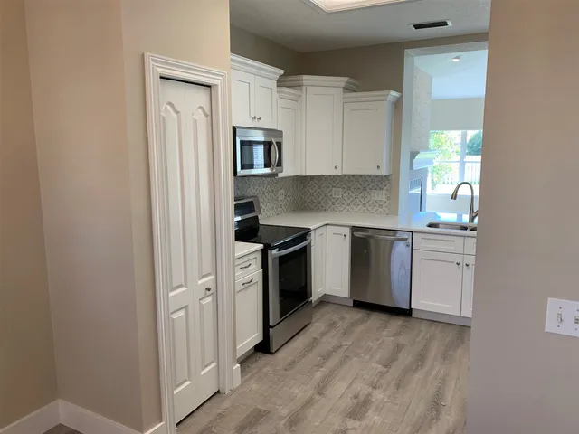 a kitchen with a white cabinets and white appliances