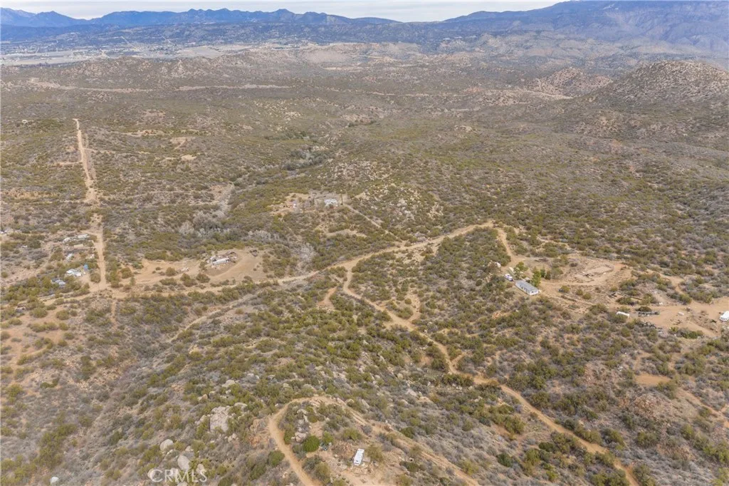 a view of a dry yard with mountains in the background