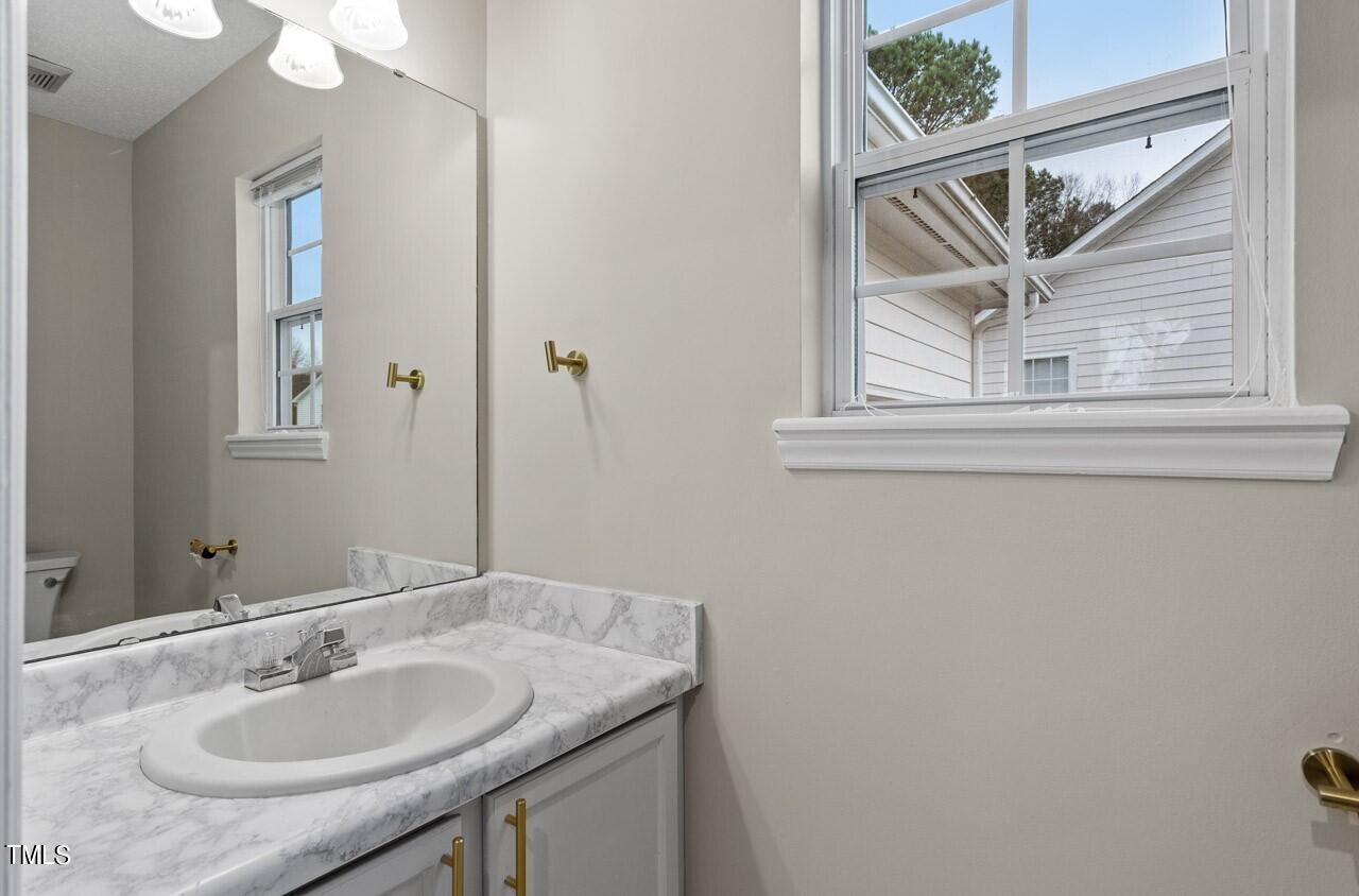 4101 Mardela Spring Drive Raleigh, NC 27616 - Photo 8 of 36 a bathroom with a granite countertop sink and a mirror