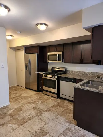 a kitchen with stainless steel appliances granite countertop a stove a sink and a refrigerator