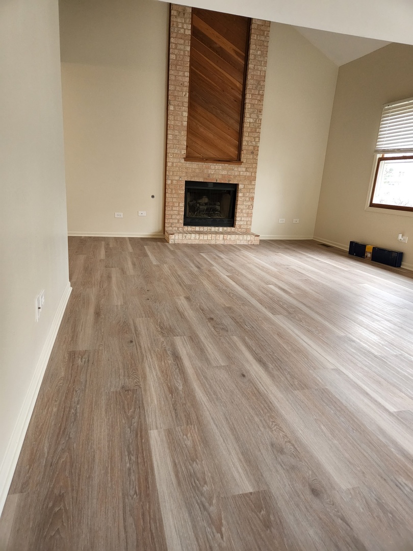 15511 Westminster Drive Orland Park, IL 60462 - Photo 4 of 16 a view of empty room with wooden floor and fireplace