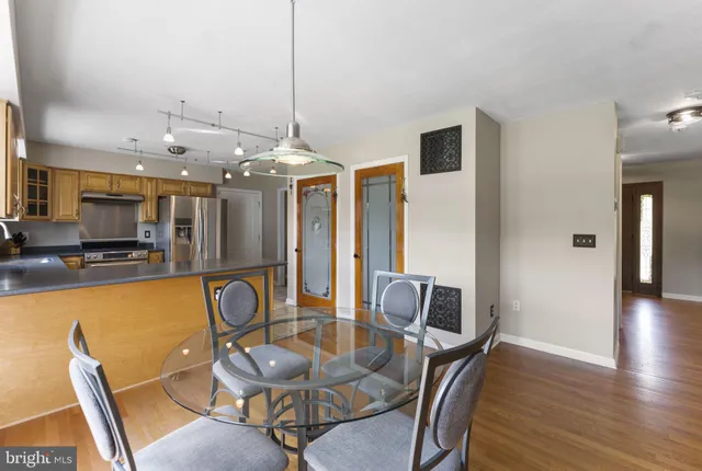 a bathroom with a granite countertop toilet a sink a mirror and a window