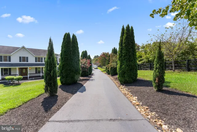a front view of a house with garden and trees