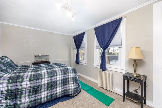 a bedroom with a bed a mirror and a window