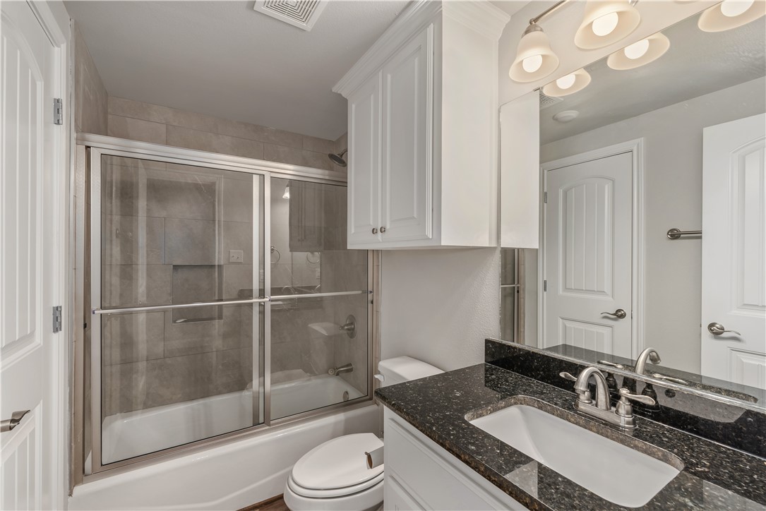 401 North Main Street, Unit 206 Bryan, TX 77803 - Photo 15 of 20 a bathroom with a granite countertop sink a toilet and shower