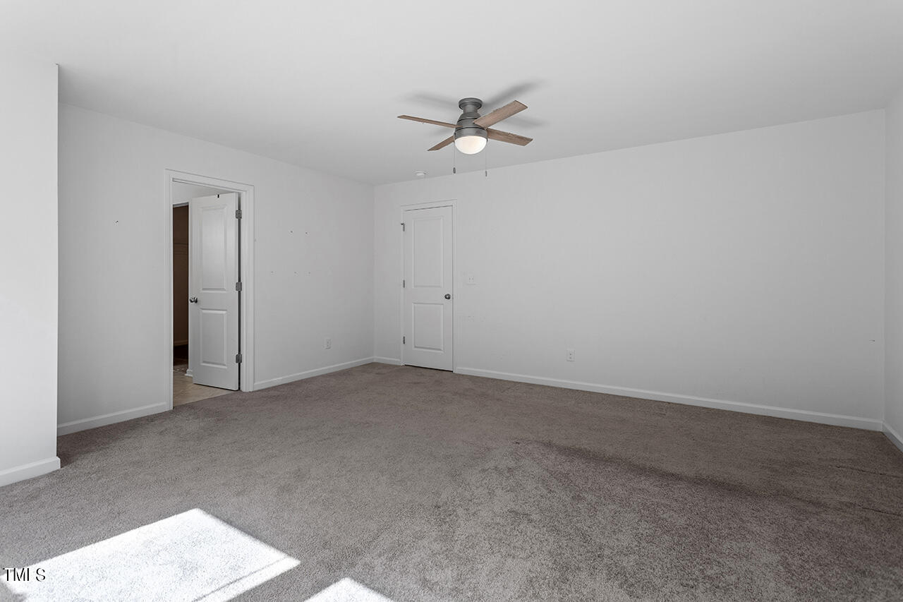 147 Pineapple Place Benson, NC 27504 - Photo 12 of 20 an empty room with a window and a ceiling fan