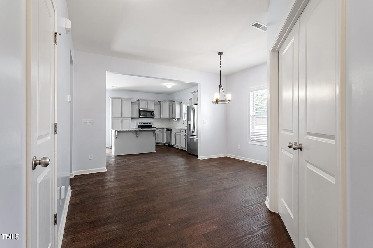 147 Pineapple Place Benson, NC 27504 - Photo 3 of 20 a view of a hallway with wooden floor and a kitchen