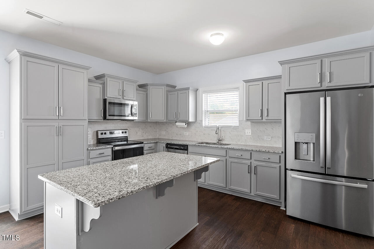 147 Pineapple Place Benson, NC 27504 - Photo 8 of 20 a kitchen with appliances a sink cabinets and wooden floor