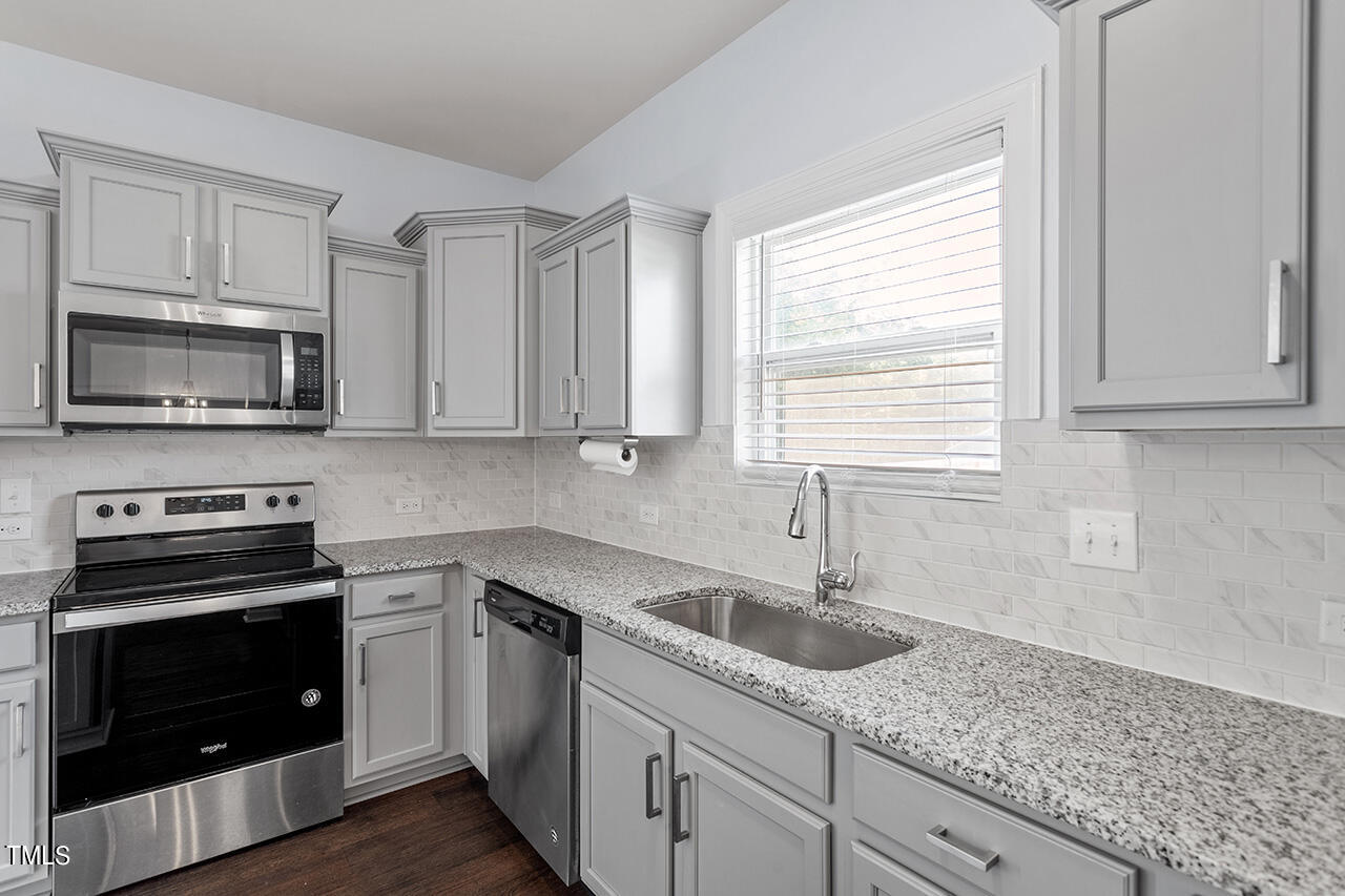 147 Pineapple Place Benson, NC 27504 - Photo 10 of 20 a kitchen with white cabinets appliances a sink and a window