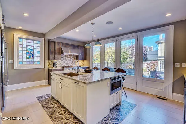 a bathroom with a granite countertop sink a mirror and a shower