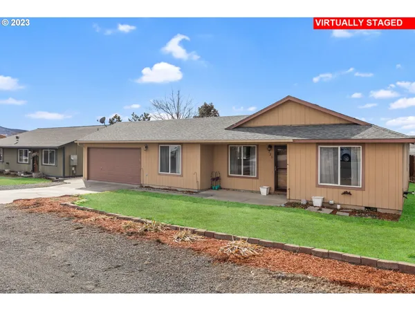 a front view of a house with a garden and yard