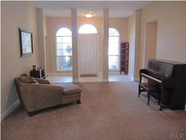 3077 Red Fern Road Cantonment, FL 32533 - Photo 2 of 25 View of living room & foyer from sliding doors to the sunroom. Dining room to the left of front door. Case opening to the left of the piano is hallway to additional bedrooms & baths.