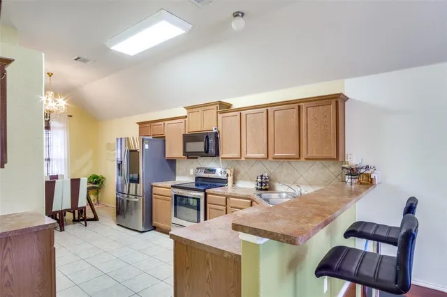 a room with furniture a flat screen tv and kitchen view