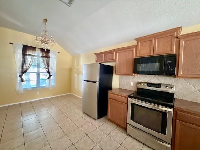 a kitchen with stainless steel appliances granite countertop a stove a sink and a microwave
