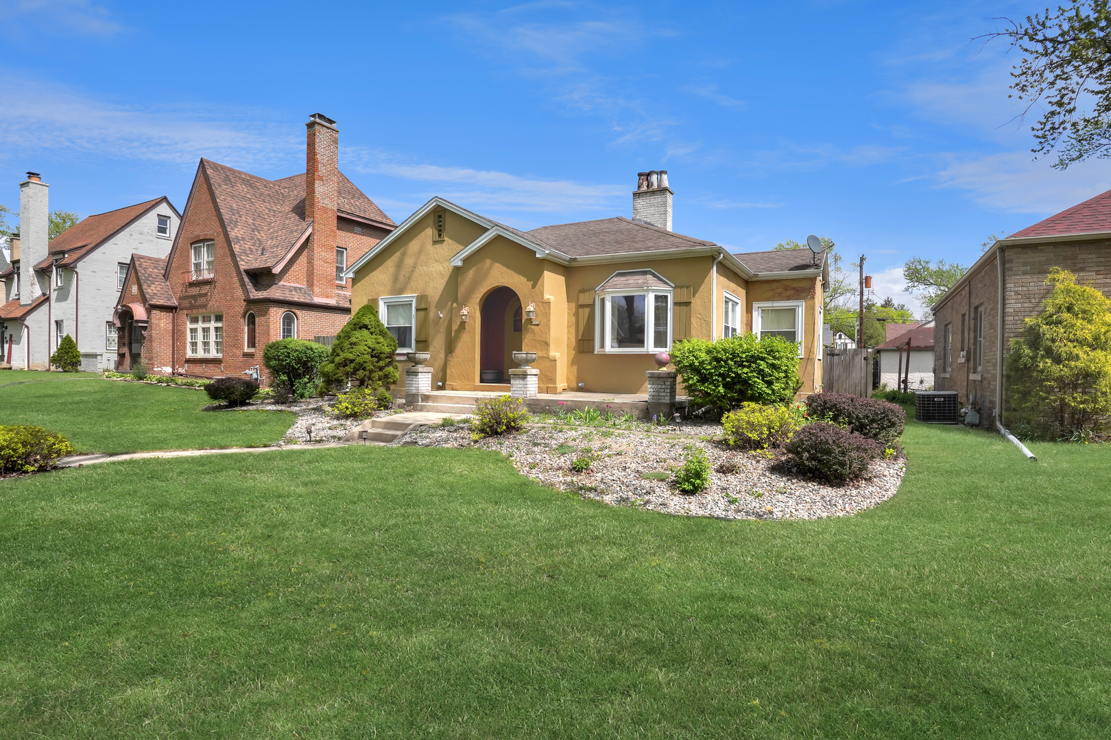 a front view of a house with a garden and plants
