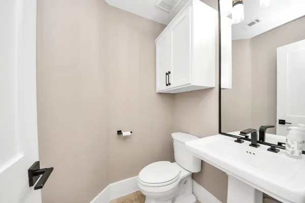 a bathroom with a sink a toilet and mirror