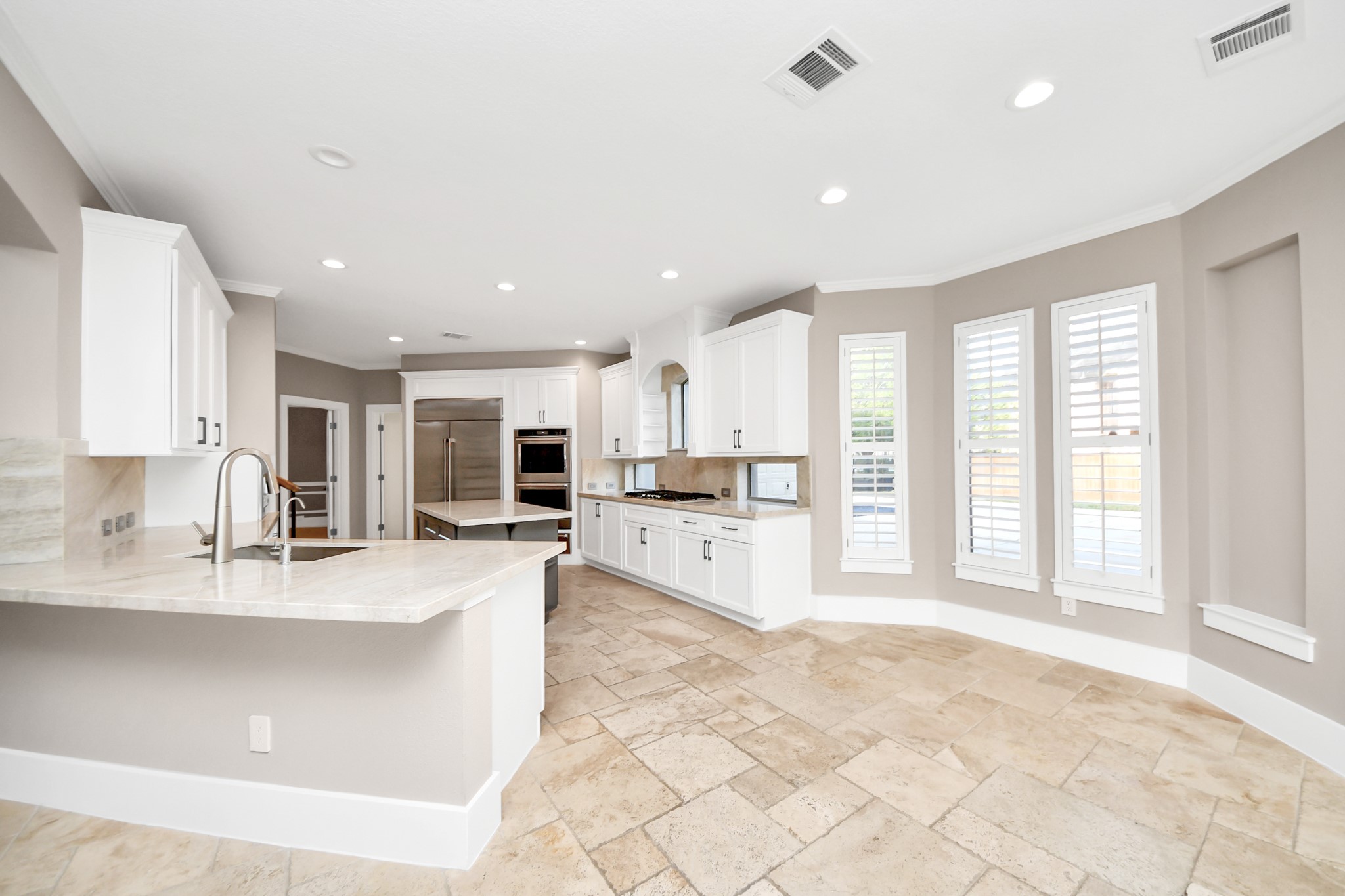 2211 Braer Ridge Drive Katy, TX 77494 - Photo 29 of 50 a large white kitchen with kitchen island a large counter top space a sink stainless steel appliances and cabinets