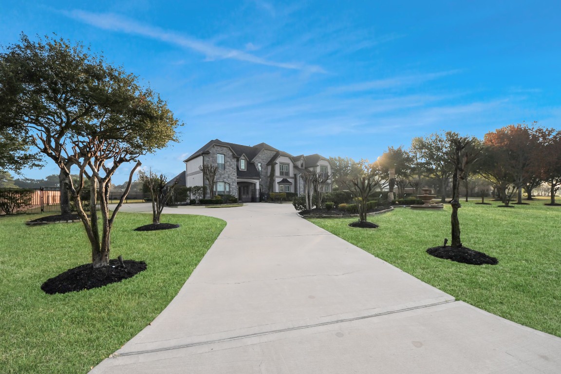 2211 Braer Ridge Drive Katy, TX 77494 - Photo 3 of 50 This elegant home features a grand entrance with one of two long driveways, manicured lawns, and mature trees, offering a spacious and inviting exterior.