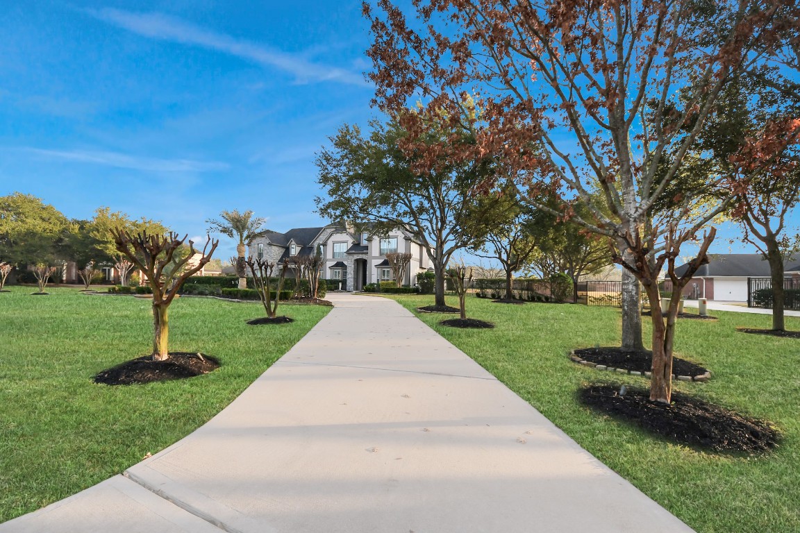 2211 Braer Ridge Drive Katy, TX 77494 - Photo 4 of 50 This elegant home features a grand entrance with one of two long driveways, manicured lawns, and mature trees, offering a spacious and inviting exterior.