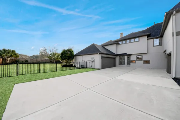 a view of a house with a yard and a large tree