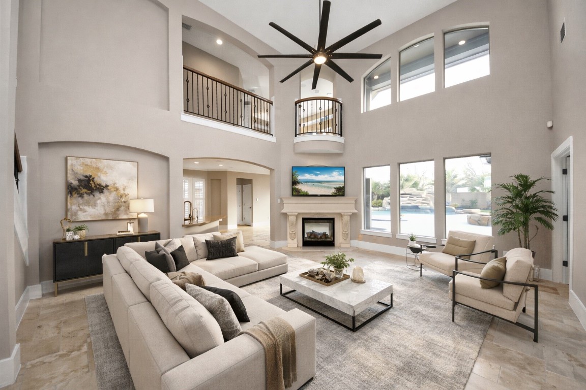 2211 Braer Ridge Drive Katy, TX 77494 - Photo 9 of 50 This spacious living room features high ceilings, large windows with pool views, and a modern open layout. It includes a cozy fireplace, elegant balcony, and stylish contemporary furnishings for a luxurious feel.
