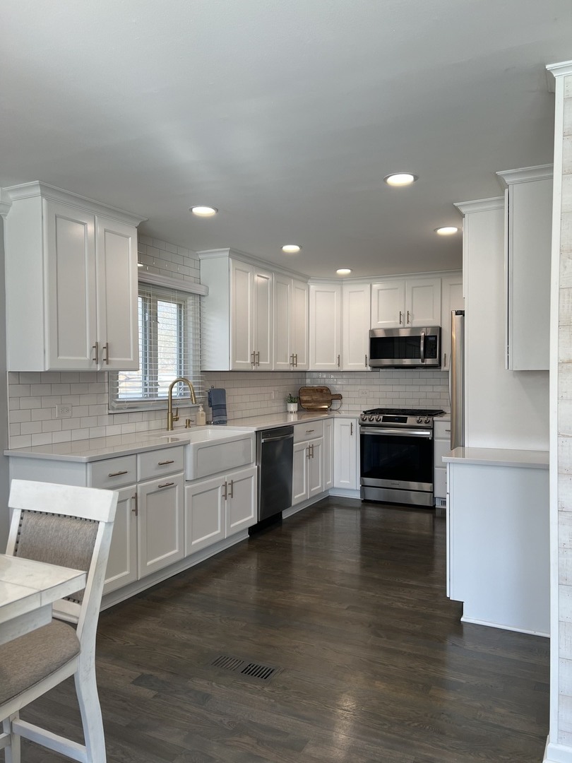 1634 Burr Oak Road Homewood, IL 60430 - Photo 6 of 36 a large kitchen with cabinets wooden floor and stainless steel appliances