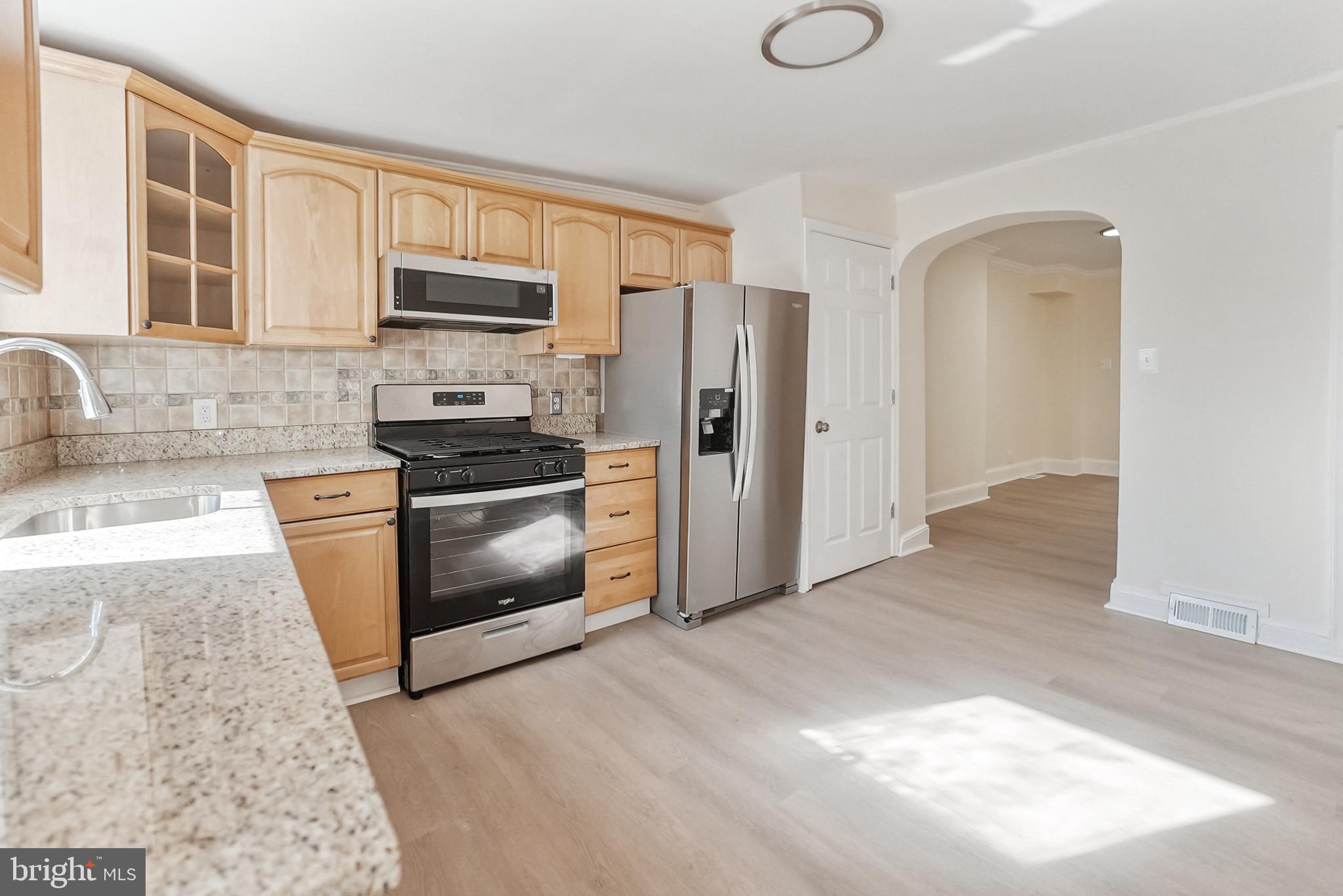 2725 Hudson Street Baltimore, MD 21224 - Photo 29 of 66 a kitchen with stainless steel appliances granite countertop a stove a sink and a refrigerator