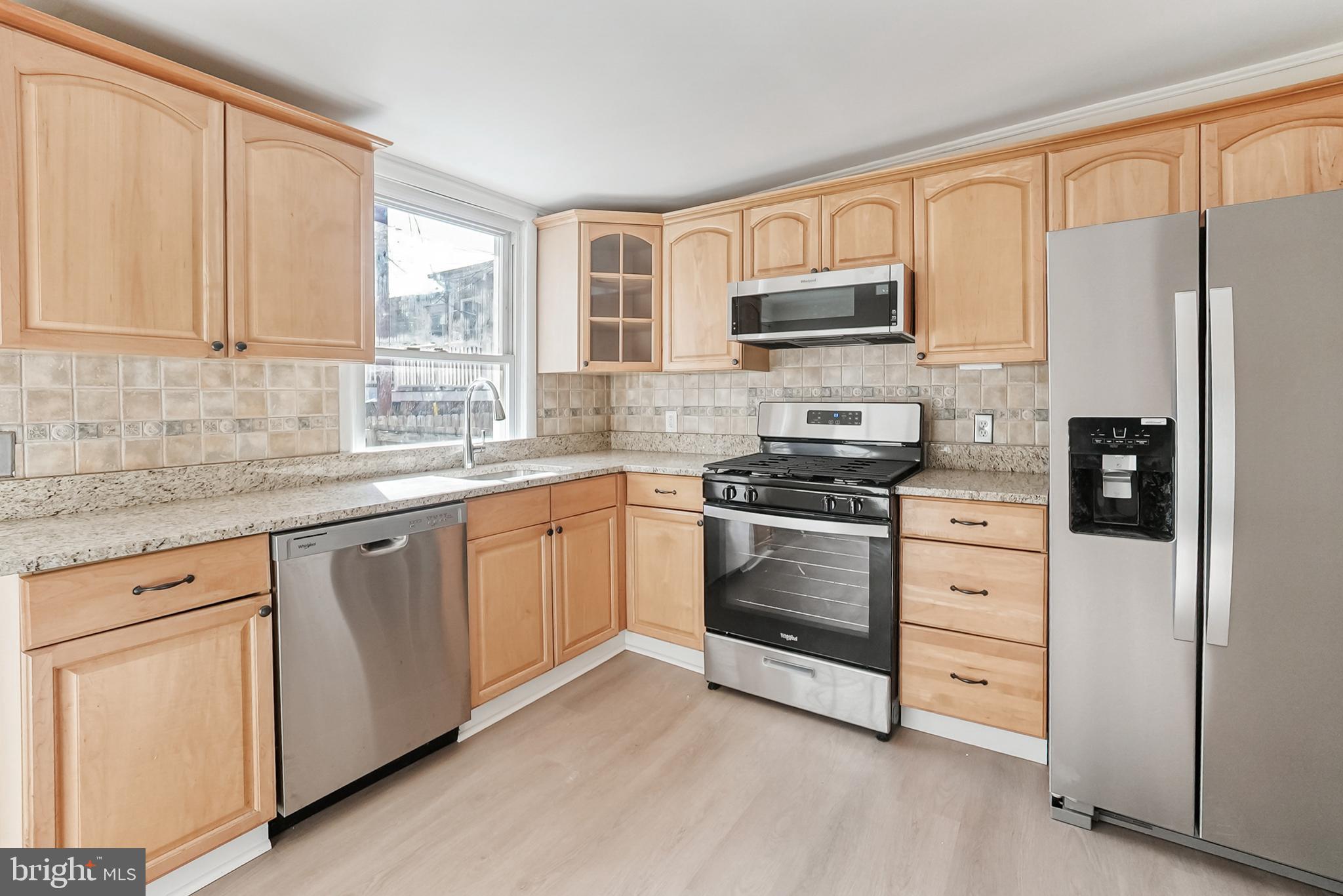 2725 Hudson Street Baltimore, MD 21224 - Photo 30 of 66 a kitchen with granite countertop white cabinets and stainless steel appliances