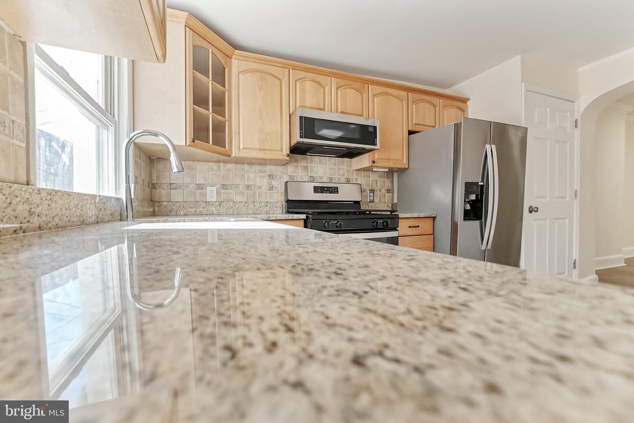 2725 Hudson Street Baltimore, MD 21224 - Photo 34 of 66 a kitchen with stainless steel appliances granite countertop a refrigerator a stove top oven a sink and dishwasher