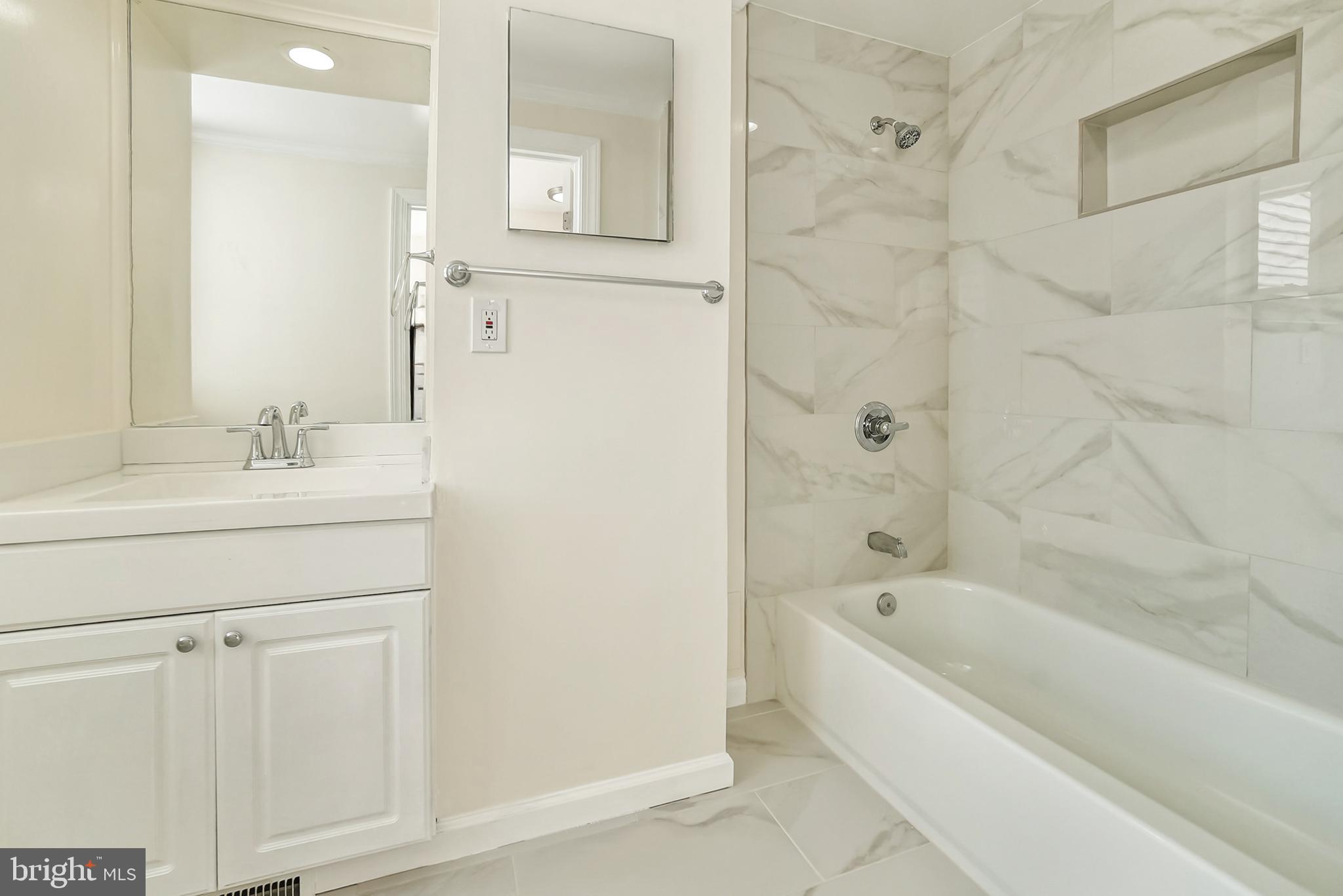 2725 Hudson Street Baltimore, MD 21224 - Photo 39 of 66 a bathroom with a bathtub a sink a vanity and a shower