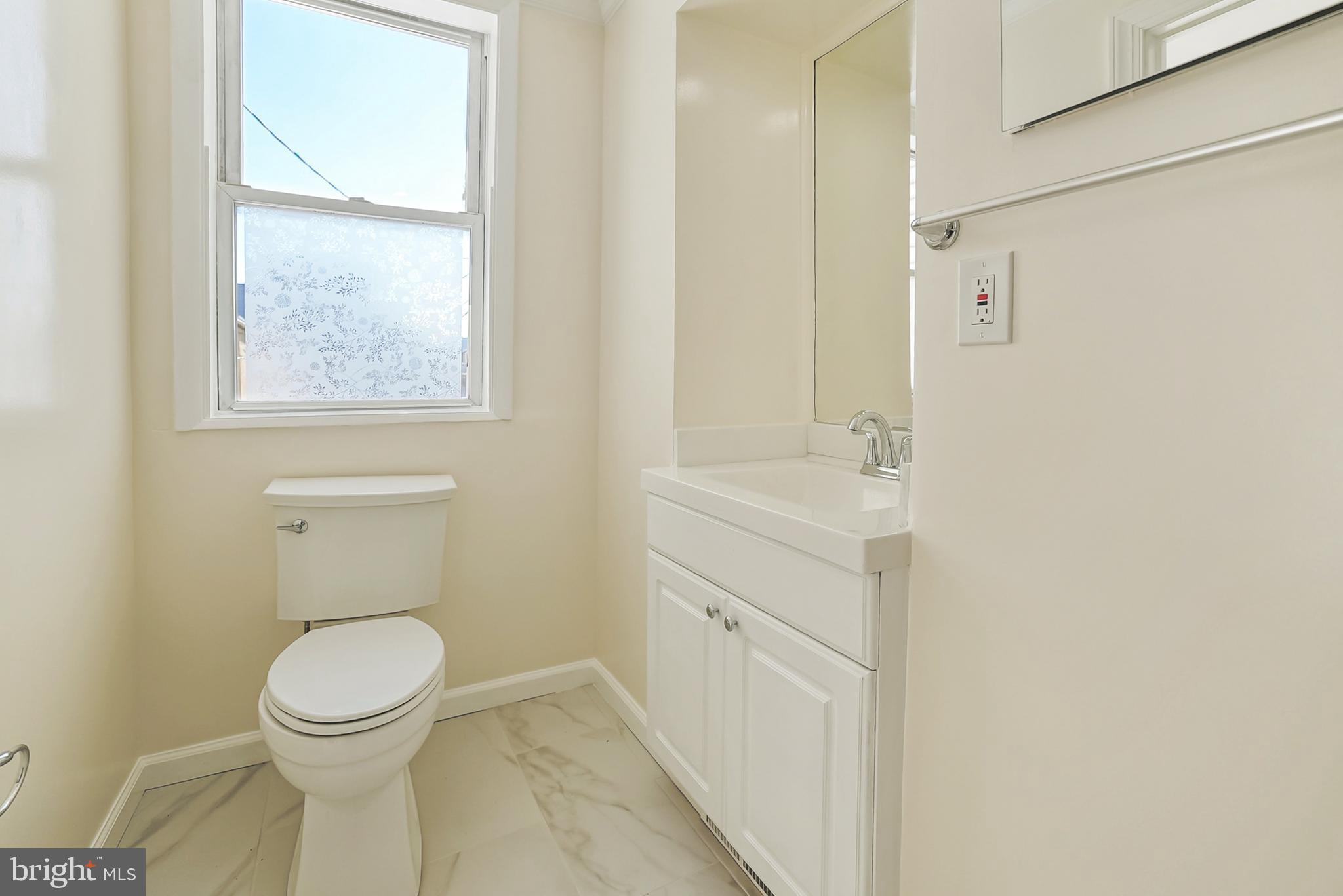 2725 Hudson Street Baltimore, MD 21224 - Photo 41 of 66 a bathroom with a toilet sink and a mirror