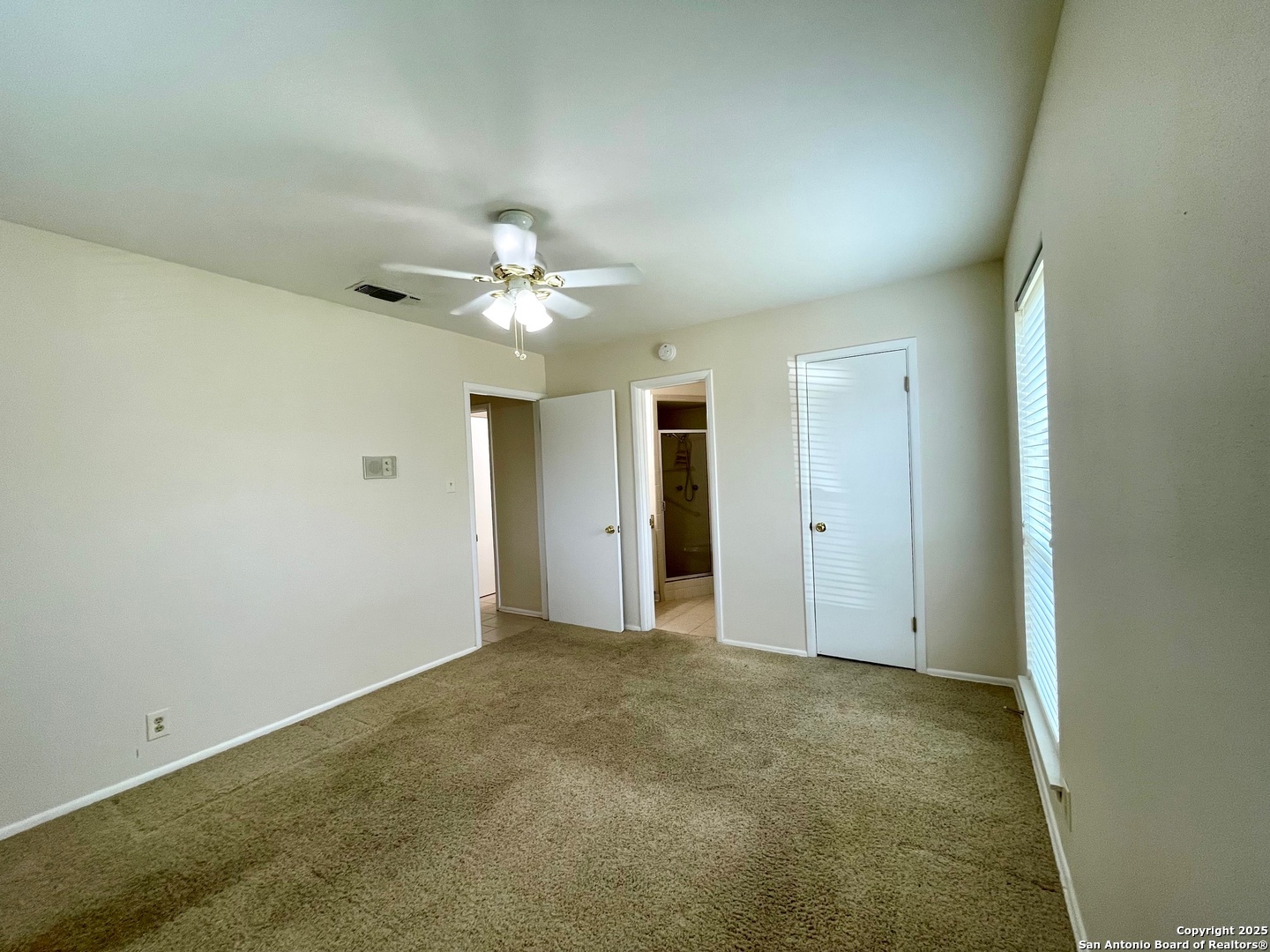 6714 Straw Flower Street Leon Valley, TX 78238 - Photo 12 of 23 an empty room with chandelier fan and windows