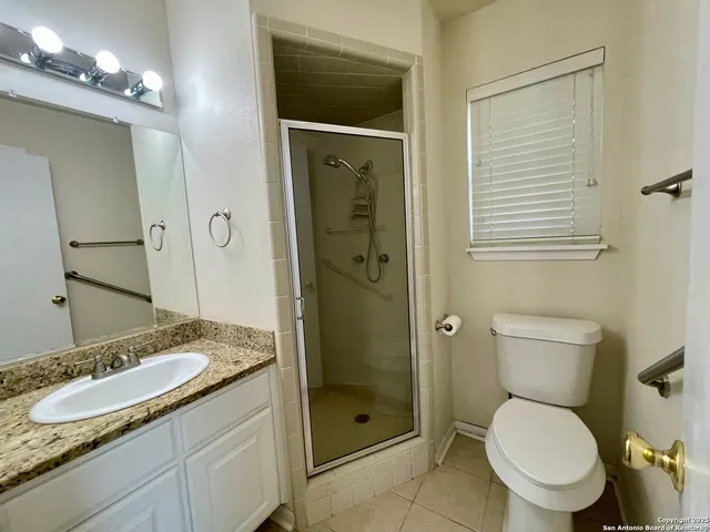 a bathroom with a granite countertop toilet sink and shower