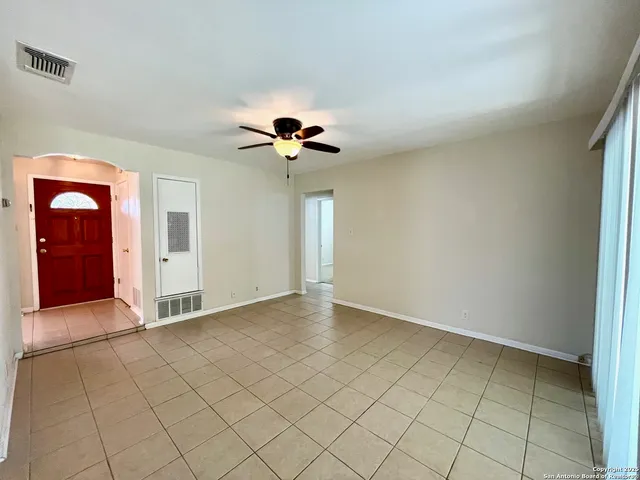 an empty room with closet and chandelier fan