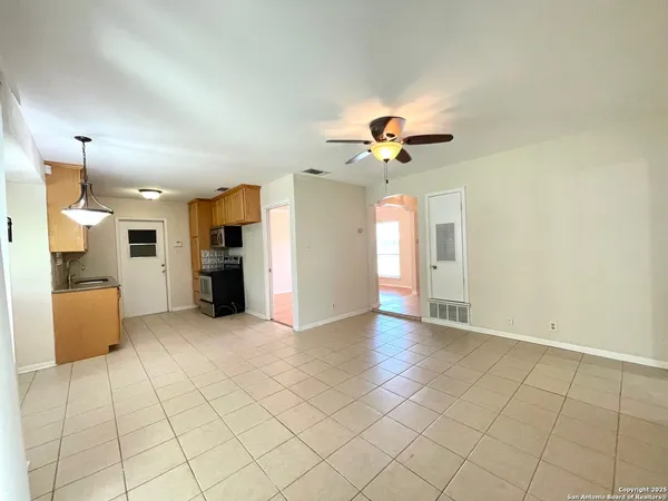 a view of an empty room with a kitchen