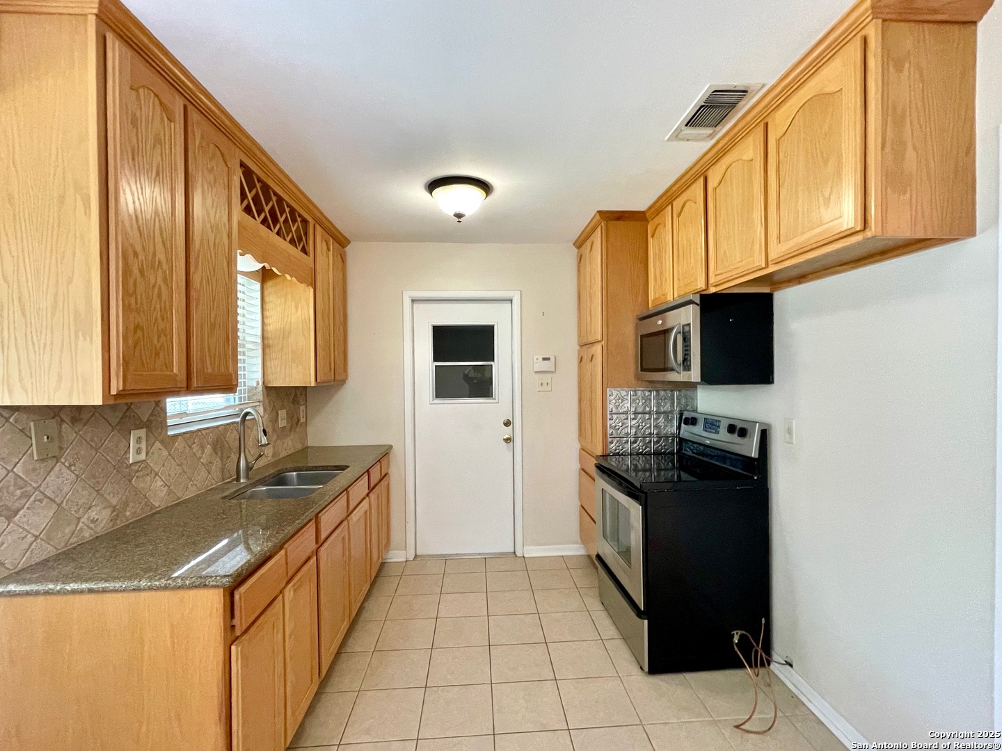 6714 Straw Flower Street Leon Valley, TX 78238 - Photo 9 of 23 a kitchen with stainless steel appliances granite countertop a sink stove and refrigerator