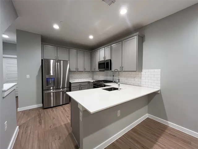 a kitchen with stainless steel appliances a sink and refrigerator