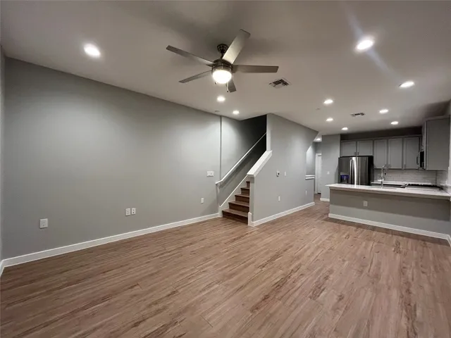 an empty room with wooden floor and entryway