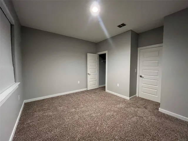 an empty room with closet and windows