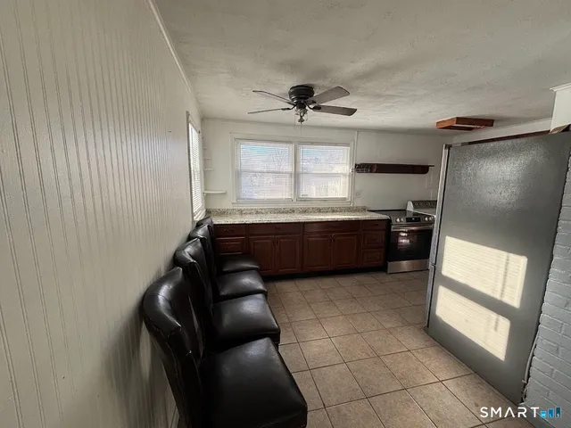 a kitchen with granite countertop a refrigerator and a sink