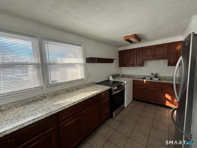 a kitchen with stainless steel appliances granite countertop a stove a sink and a microwave