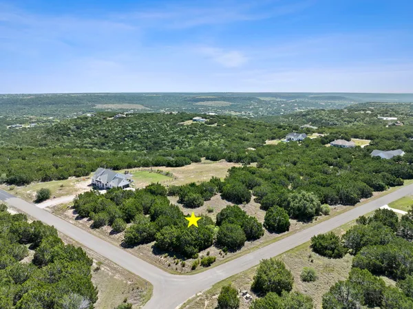 an aerial view of a houses with a yard and lake view