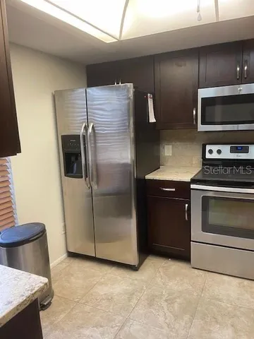a kitchen with granite countertop a refrigerator and a stove