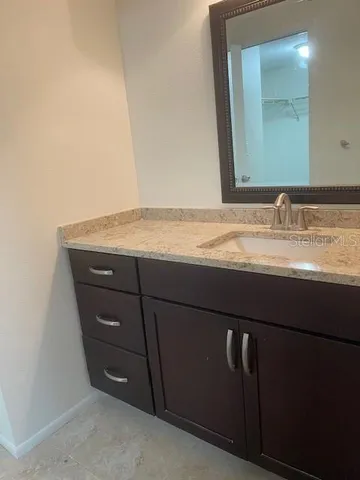 a bathroom with a granite countertop sink and a mirror