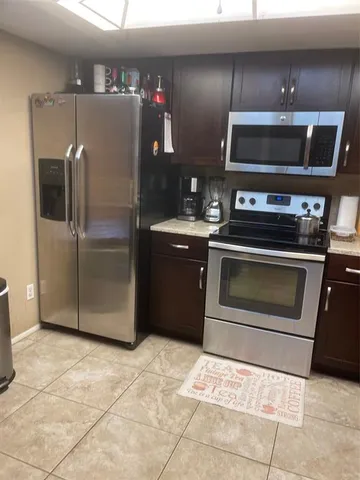 a kitchen with granite countertop a refrigerator and a stove