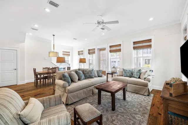 a living room with furniture wooden floor and a large window